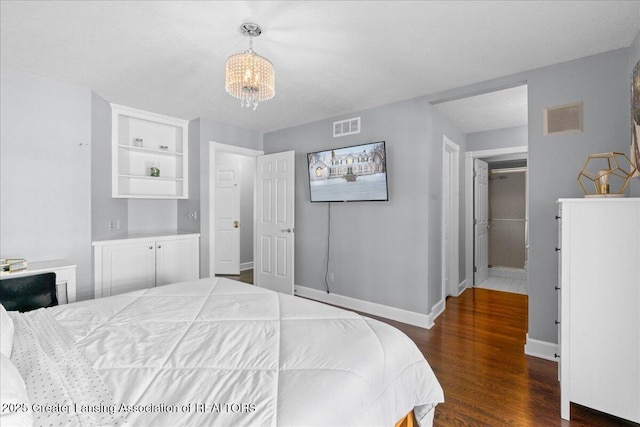 bedroom featuring dark hardwood / wood-style floors, a notable chandelier, and a closet