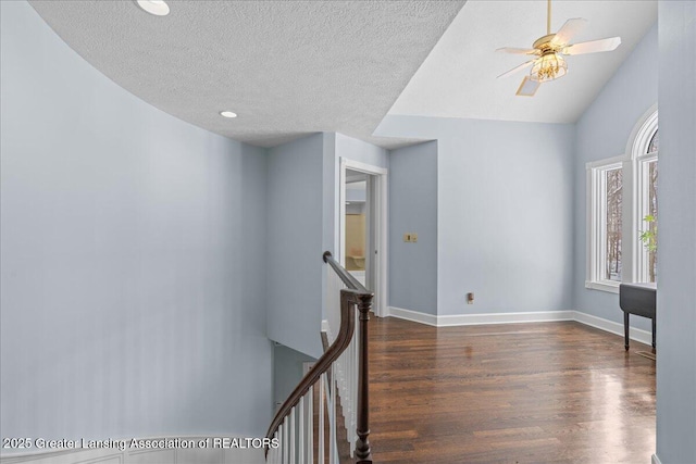 spare room featuring dark hardwood / wood-style flooring, ceiling fan, lofted ceiling, and a textured ceiling