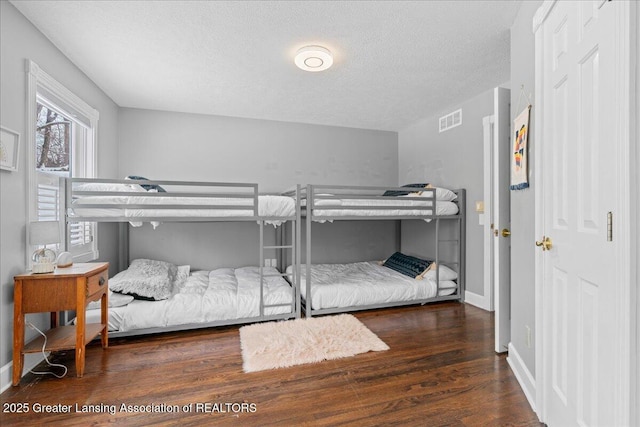 bedroom with dark hardwood / wood-style flooring and a textured ceiling