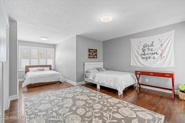 bedroom with dark wood-type flooring and a textured ceiling