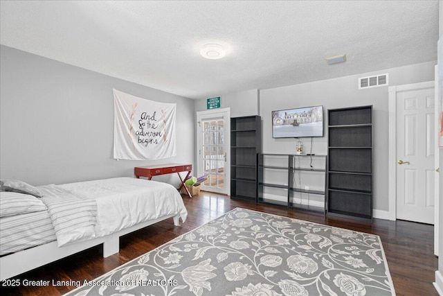 bedroom featuring dark wood-type flooring and a textured ceiling