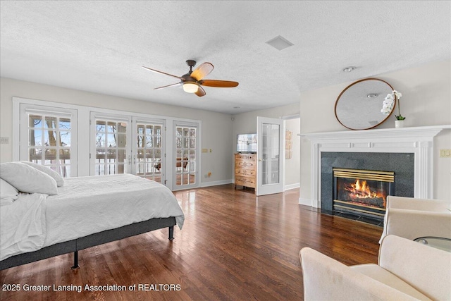 bedroom featuring french doors, ceiling fan, multiple windows, and a textured ceiling