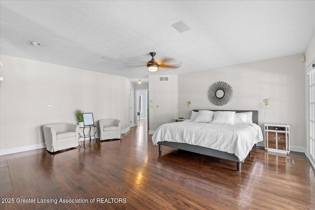 bedroom featuring ceiling fan, dark hardwood / wood-style floors, and a textured ceiling