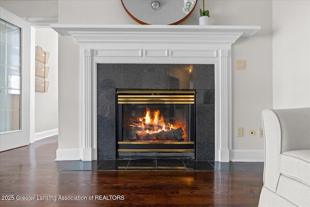 interior details with a tiled fireplace and hardwood / wood-style floors