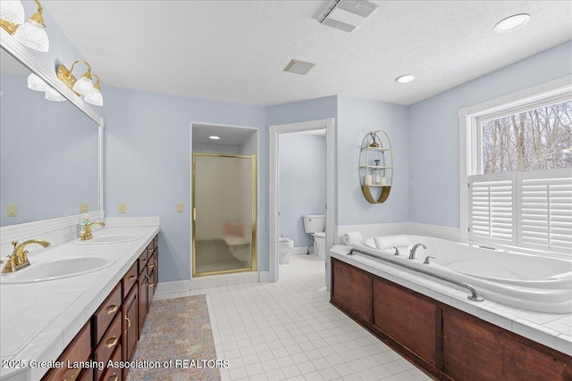 full bathroom featuring independent shower and bath, vanity, toilet, tile patterned floors, and a textured ceiling