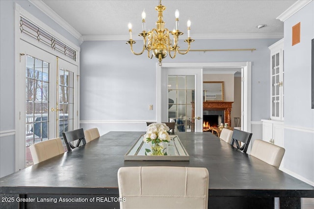 dining space with french doors, crown molding, a textured ceiling, and a notable chandelier