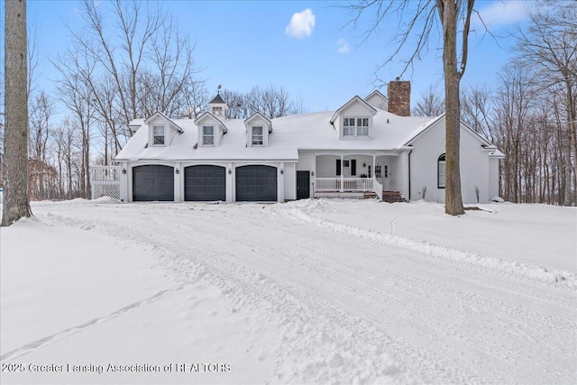 cape cod home featuring a garage and covered porch