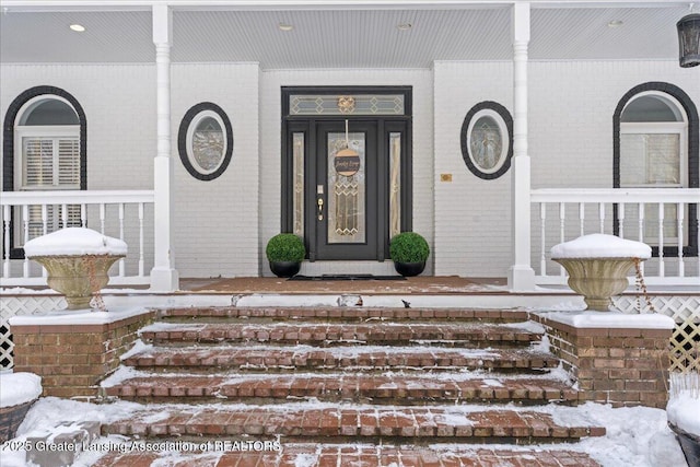 view of exterior entry featuring covered porch