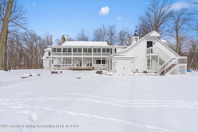 snow covered property with a sunroom