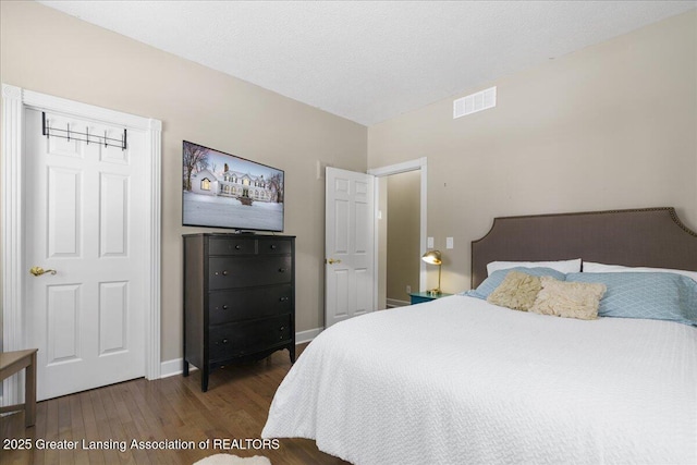 bedroom with dark hardwood / wood-style flooring and a textured ceiling