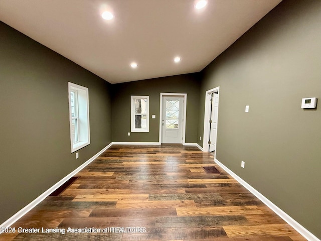 entrance foyer with dark wood-type flooring and vaulted ceiling