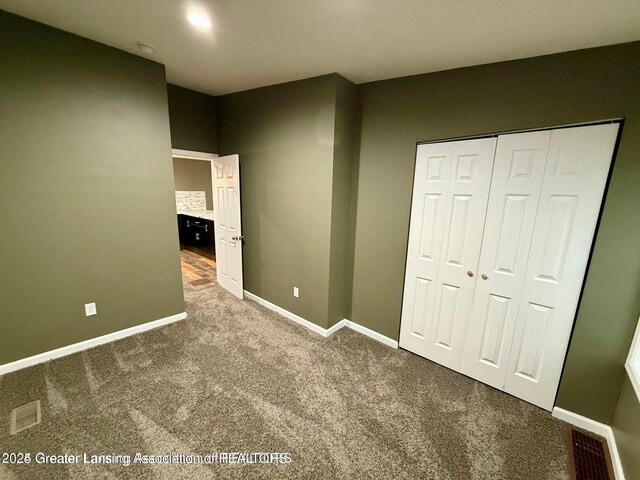 unfurnished bedroom featuring carpet flooring and a closet