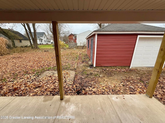 view of yard featuring a garage and an outbuilding