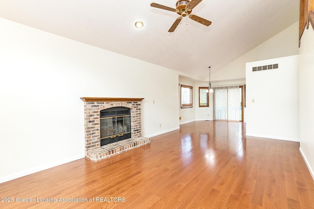 unfurnished living room with wood-type flooring, a brick fireplace, high vaulted ceiling, and ceiling fan