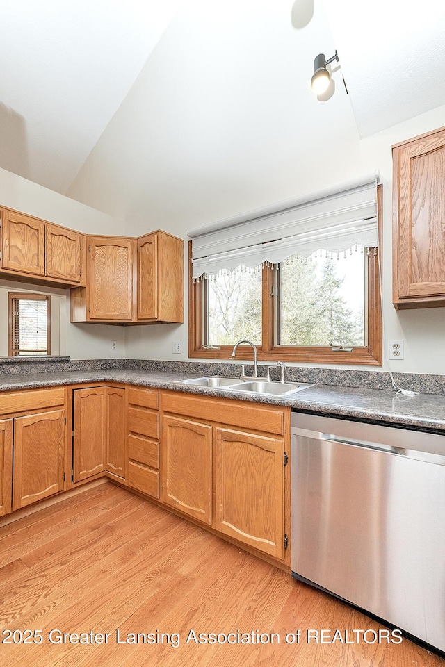 kitchen with lofted ceiling, dishwasher, sink, and light wood-type flooring