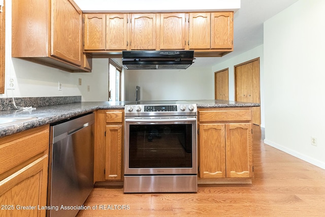 kitchen with stainless steel appliances, kitchen peninsula, light wood-type flooring, and exhaust hood