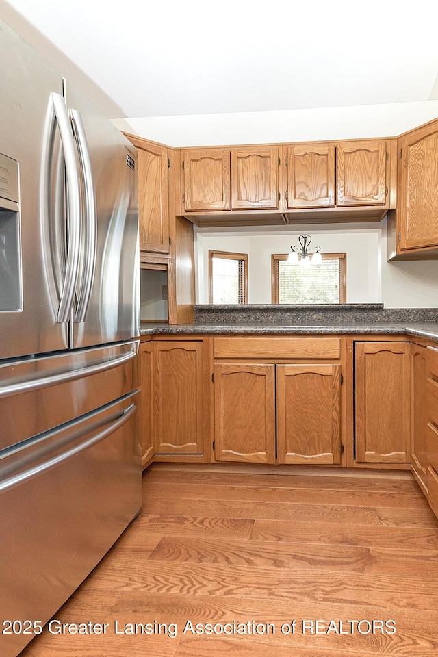 kitchen with light hardwood / wood-style floors and stainless steel fridge with ice dispenser