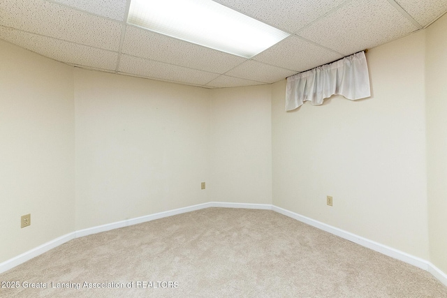 basement featuring carpet floors and a paneled ceiling