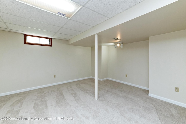 basement with light colored carpet and a drop ceiling