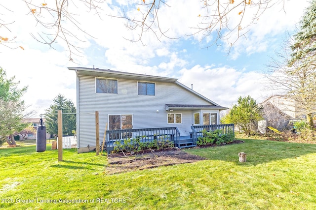 rear view of house featuring a wooden deck and a yard