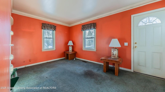 entrance foyer featuring ornamental molding and dark carpet