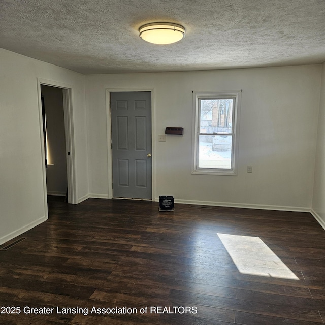 entrance foyer with dark hardwood / wood-style flooring and a textured ceiling