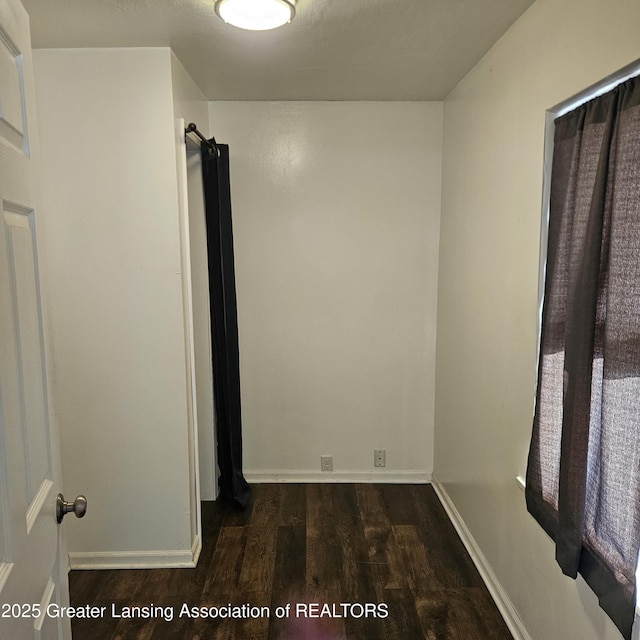 unfurnished room with dark hardwood / wood-style flooring