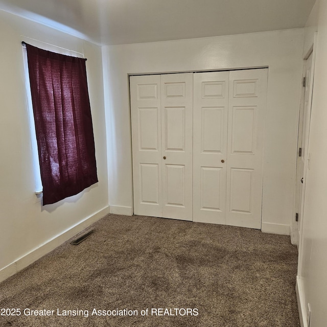 unfurnished bedroom featuring carpet flooring and a closet