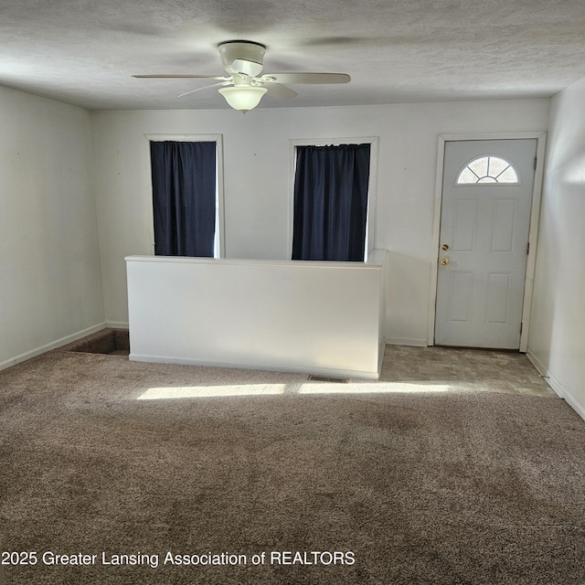 foyer with ceiling fan, carpet flooring, and a textured ceiling