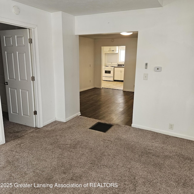 unfurnished room with dark colored carpet