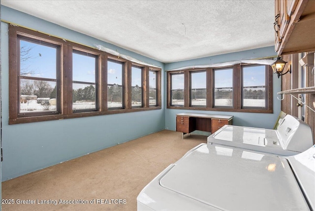 washroom featuring cabinets, washing machine and dryer, light colored carpet, and a textured ceiling