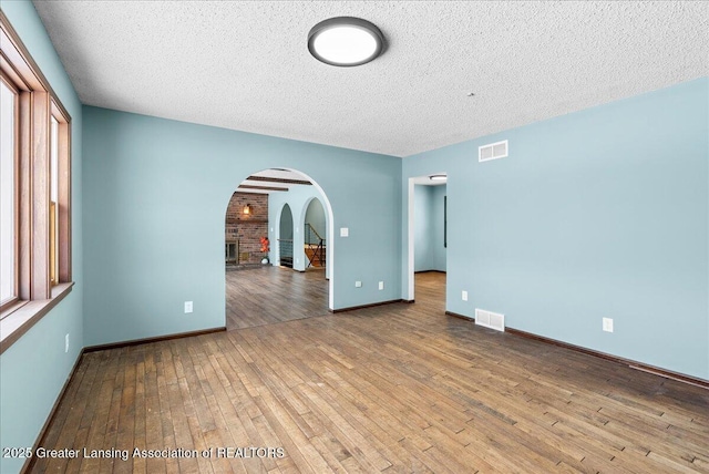 empty room featuring wood-type flooring and a textured ceiling