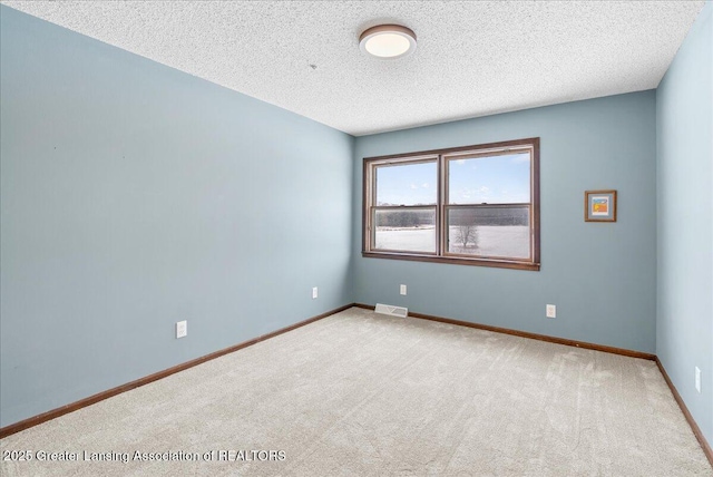 carpeted spare room with a textured ceiling