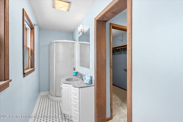 bathroom with vanity, an inviting chandelier, and walk in shower