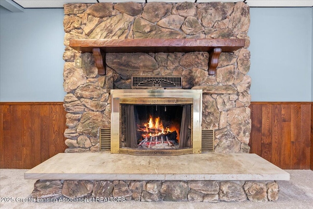 room details with a fireplace, carpet floors, and wood walls