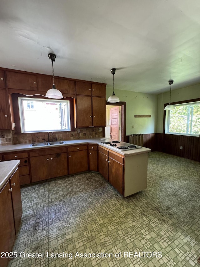 kitchen featuring pendant lighting, stovetop, sink, and tasteful backsplash