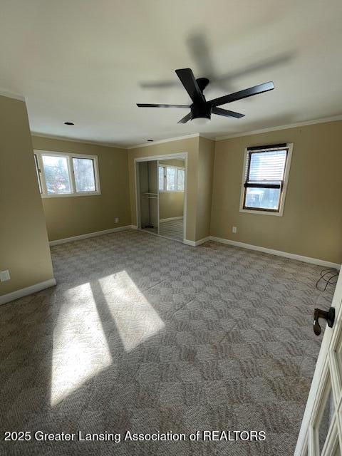 spare room featuring light carpet, ornamental molding, and ceiling fan