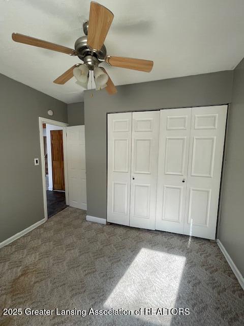 unfurnished bedroom with ceiling fan, carpet floors, and a closet