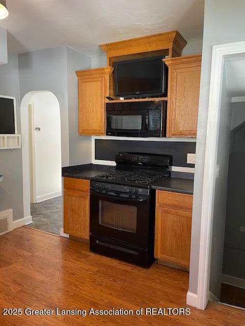 kitchen with wood-type flooring and black appliances