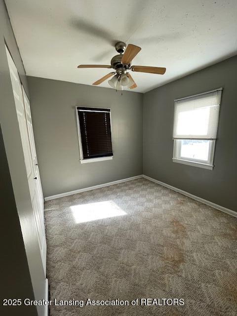 spare room featuring carpet floors and ceiling fan