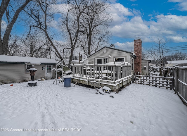 snow covered property with a wooden deck