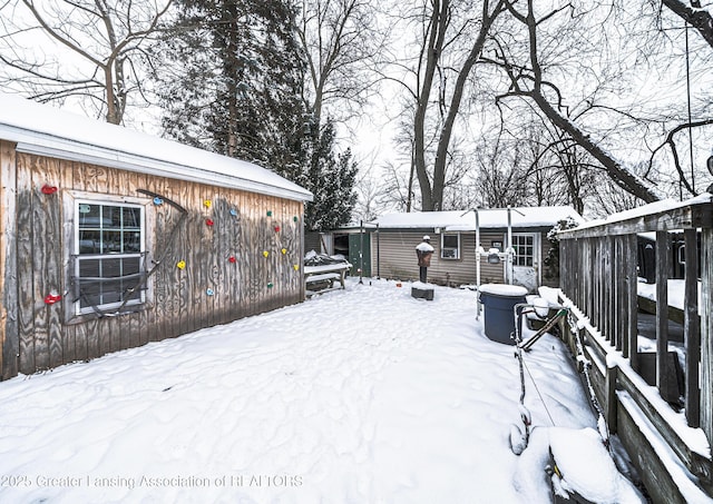 yard covered in snow featuring an outbuilding