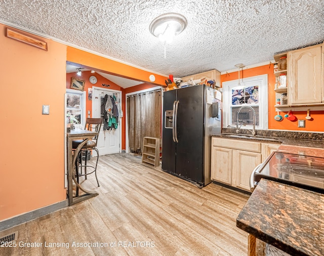 kitchen featuring sink, light brown cabinets, a textured ceiling, and stainless steel fridge with ice dispenser