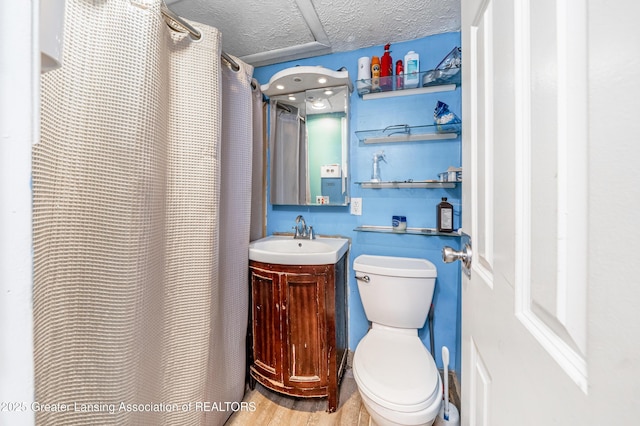 bathroom with hardwood / wood-style floors, vanity, toilet, a textured ceiling, and a shower with shower curtain