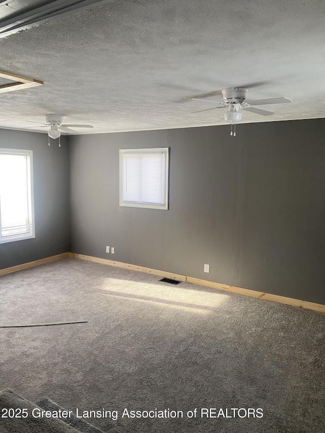 unfurnished room featuring ceiling fan, carpet floors, and a textured ceiling