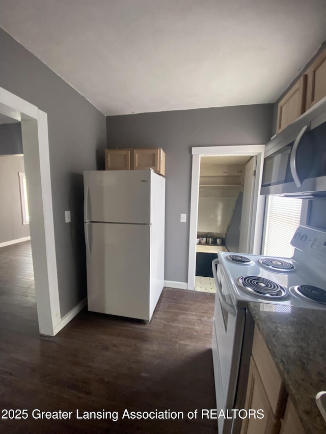 kitchen with white appliances and dark hardwood / wood-style floors