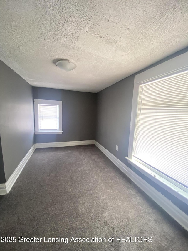 carpeted spare room featuring a textured ceiling