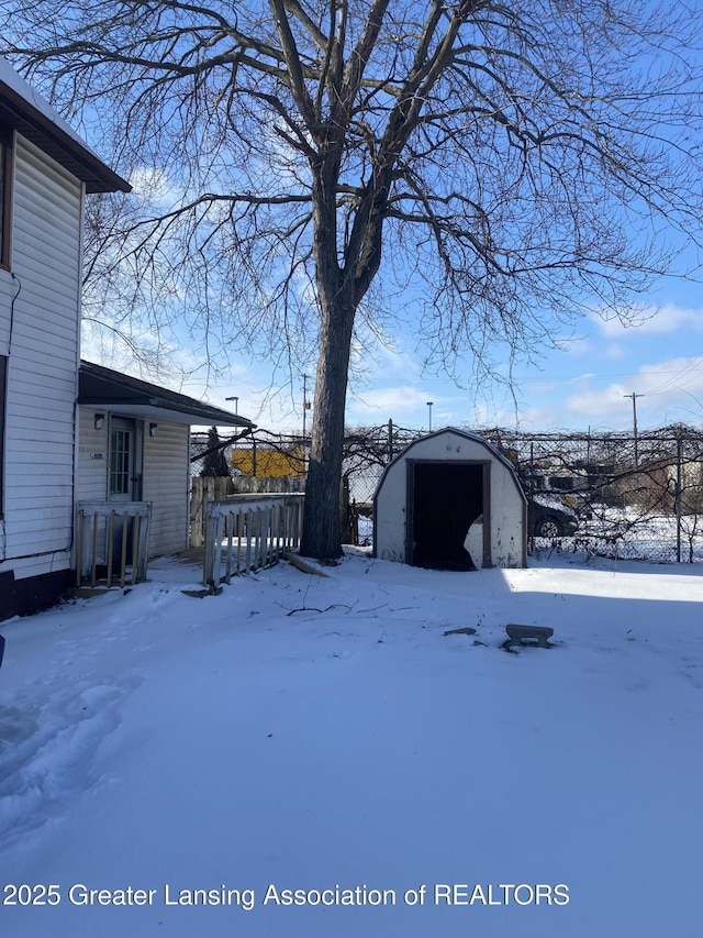 yard layered in snow with a storage unit