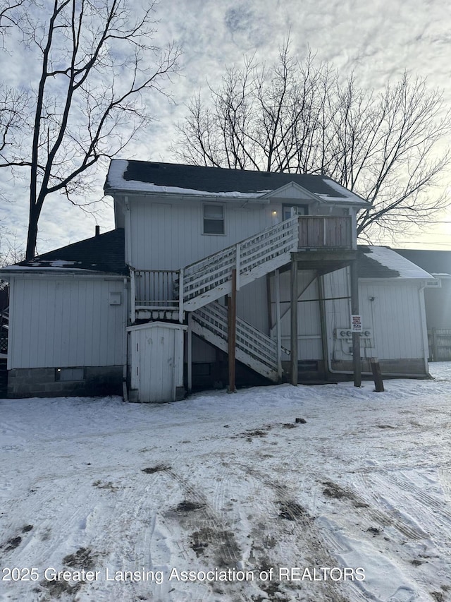 view of snow covered back of property