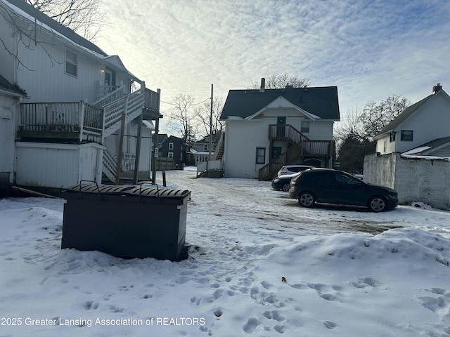 snowy yard with stairway and a residential view